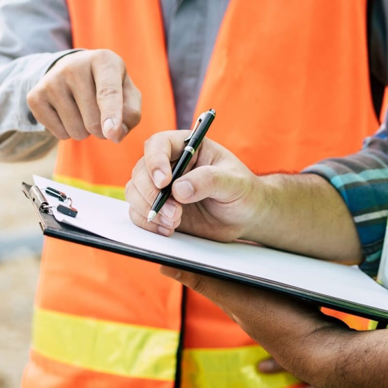 Two construction workers discussing over a blueprint